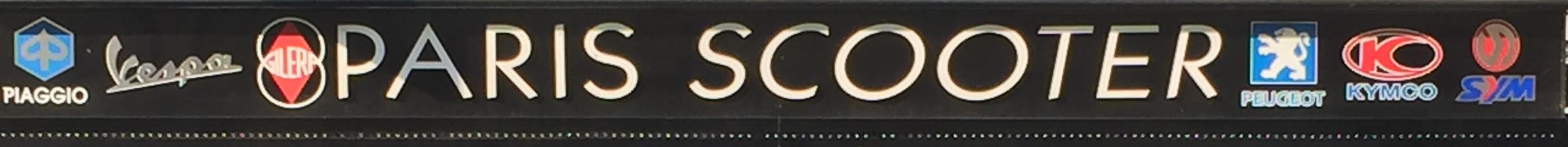 L'enseigne de la façade: Paris Scooter en lettres blanches sur bandeau noir, entre les logos Piaggio, Vespa, Gilera, Peugeot, Kymco et Sym